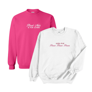 Set of two stylish crewneck sweatshirts featuring playful text designs. The pink sweatshirt reads 'Pinot Noir is for Lovers' in elegant white script, while the white sweatshirt displays 'Alexa Play Please Please Please' in bold pink and delicate red cursive. Perfect for cozy and trendy fashion enthusiasts.