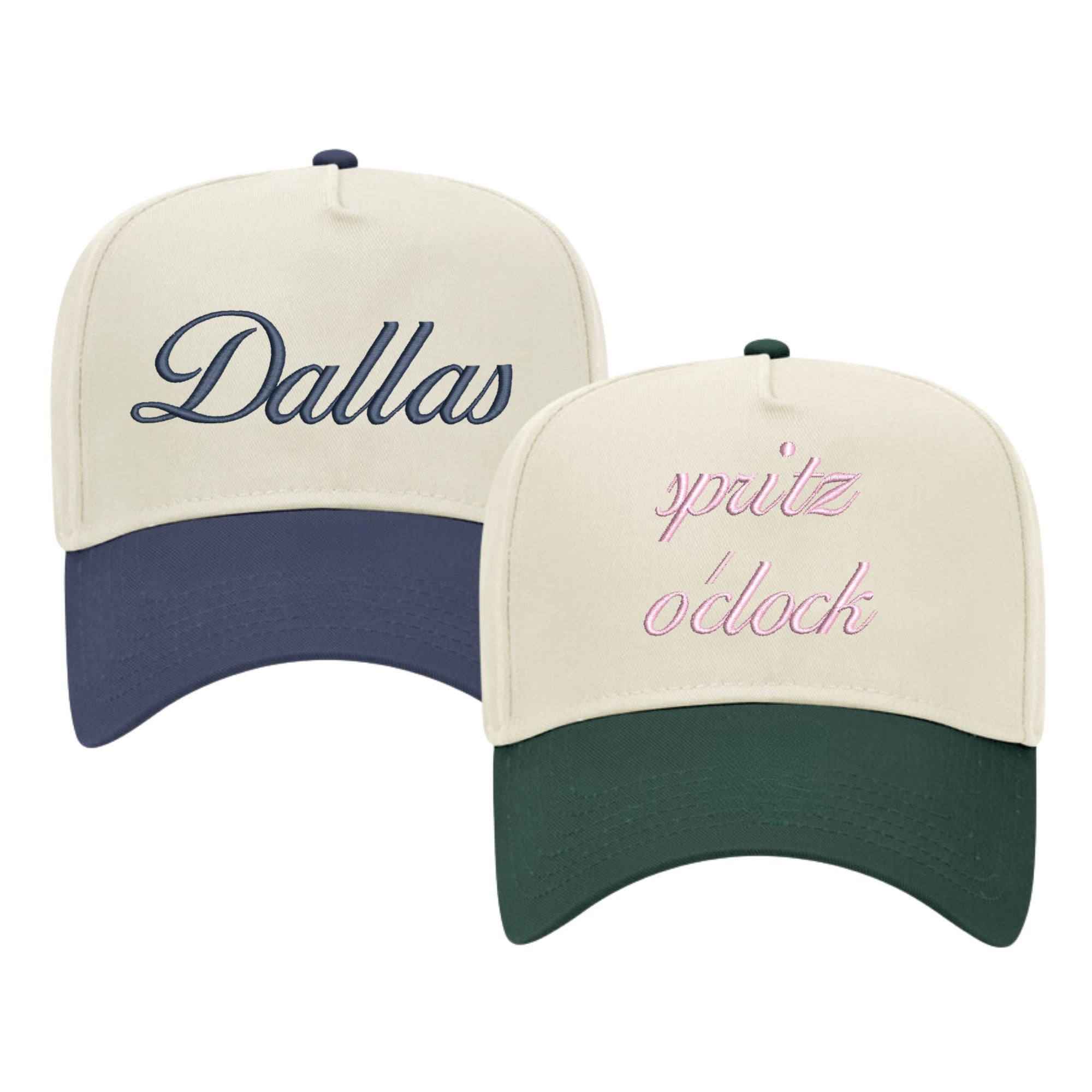 Image of two baseball caps with custom embroidery. The left cap has a cream crown and a navy blue bill, featuring the word 'Dallas' embroidered in elegant navy script. The right cap also has a cream crown but with a dark green bill, displaying the phrase 'spritz o'clock' in playful pink cursive. Both caps are structured with a classic design and have adjustable snaps at the back, suitable for personalized style or city pride.