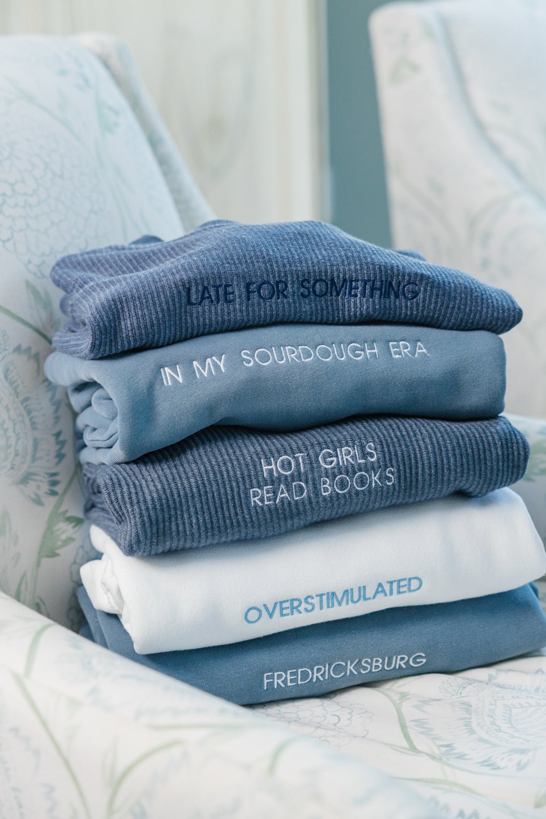 Two custom embroidered sweatshirts displayed against a white background. The first sweatshirt is beige with the text 'Espresso Martini' in brown embroidery, and the second sweatshirt is white with the text 'Marriage Material' in light blue embroidery.