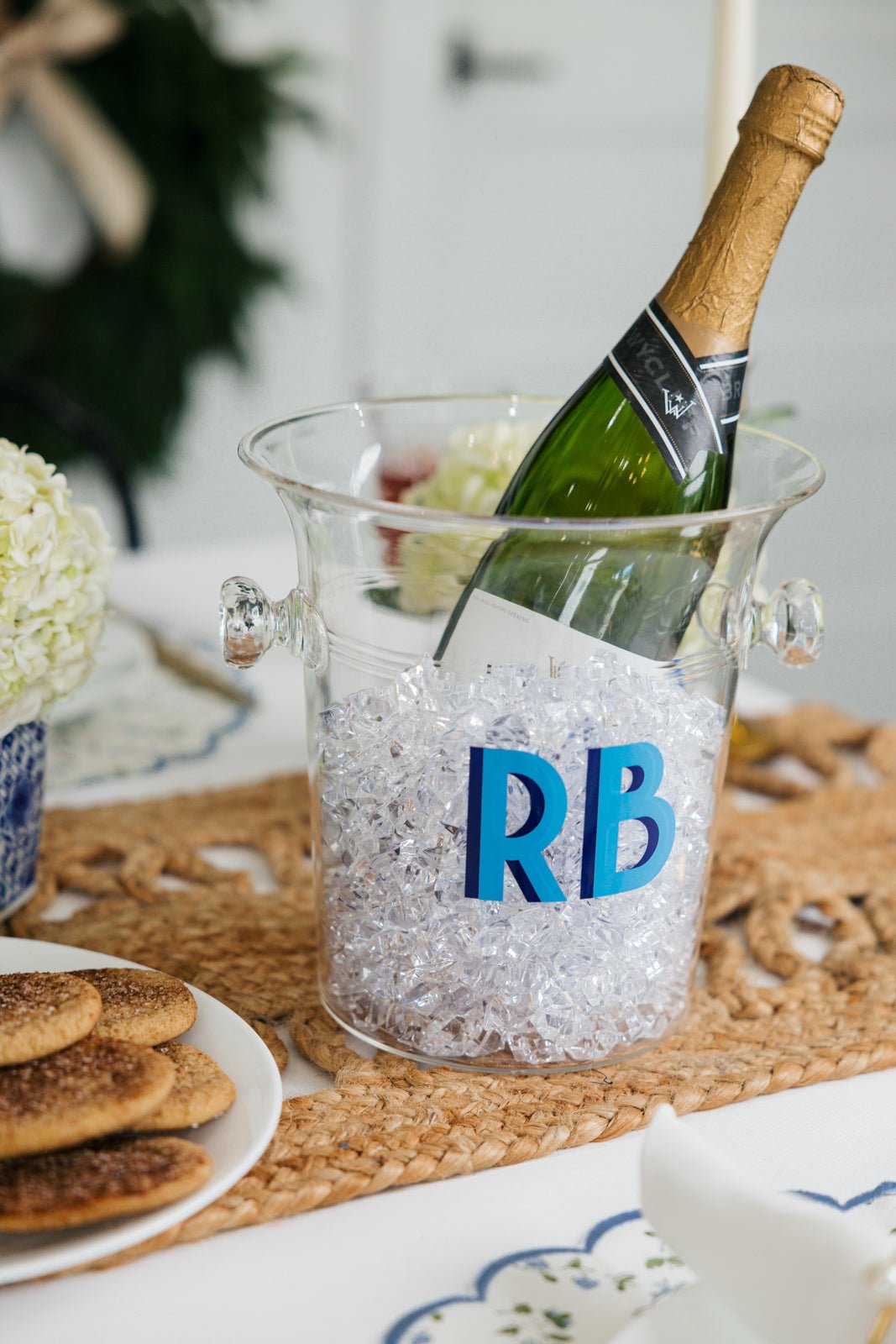 A clear ice bucket with "KE" monogrammed on the front in pink