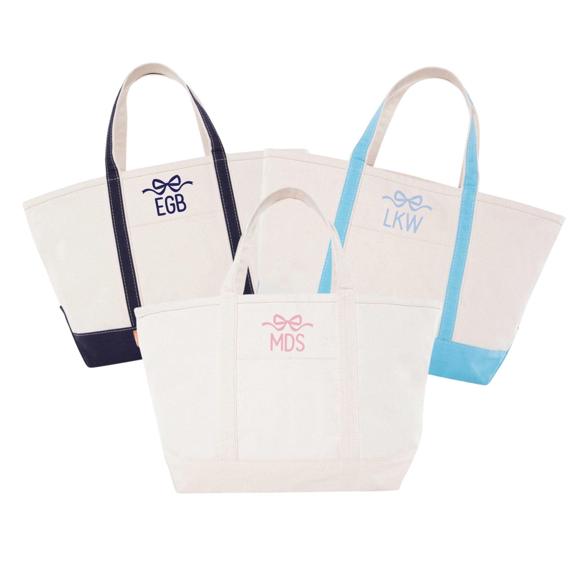 A group of canvas totes are customized with an embroidered monogram and bow design