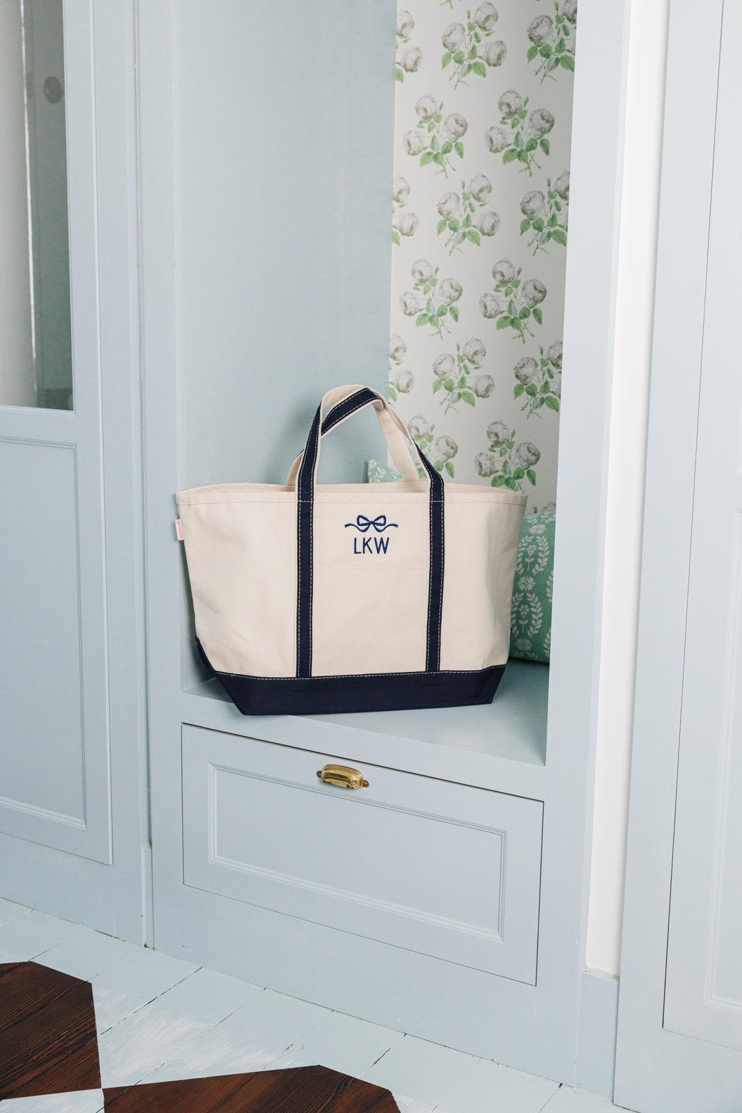 A group of canvas totes are customized with an embroidered monogram and bow design