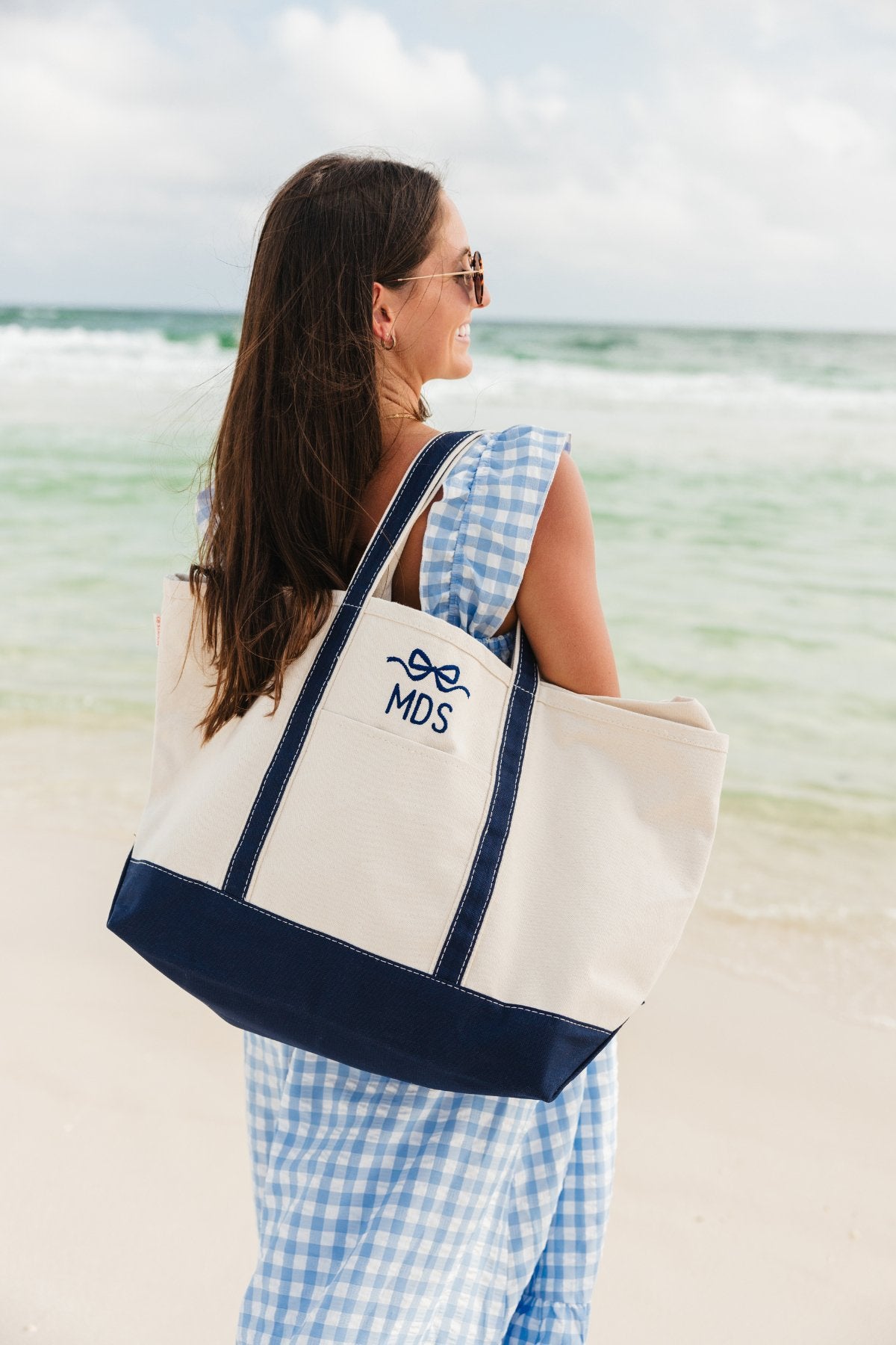 A group of canvas totes are customized with an embroidered monogram and bow design