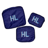 A set of three navy packing cubes are customized with a navy monogram.