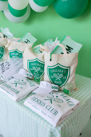 An assortment of green and white products are customized and set up for a Last Swing Before The Ring bachelorette.