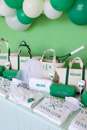 A group of green and white products are laid out for a Last Swing Before The Ring bachelorette party