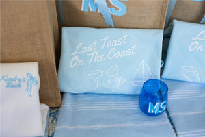 A blue sweatshirt is customized with a Last Toast On The Coast Design and is placed with other blue monogrammed products.