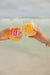 Two people cheers with their blue monogrammed wine glasses.