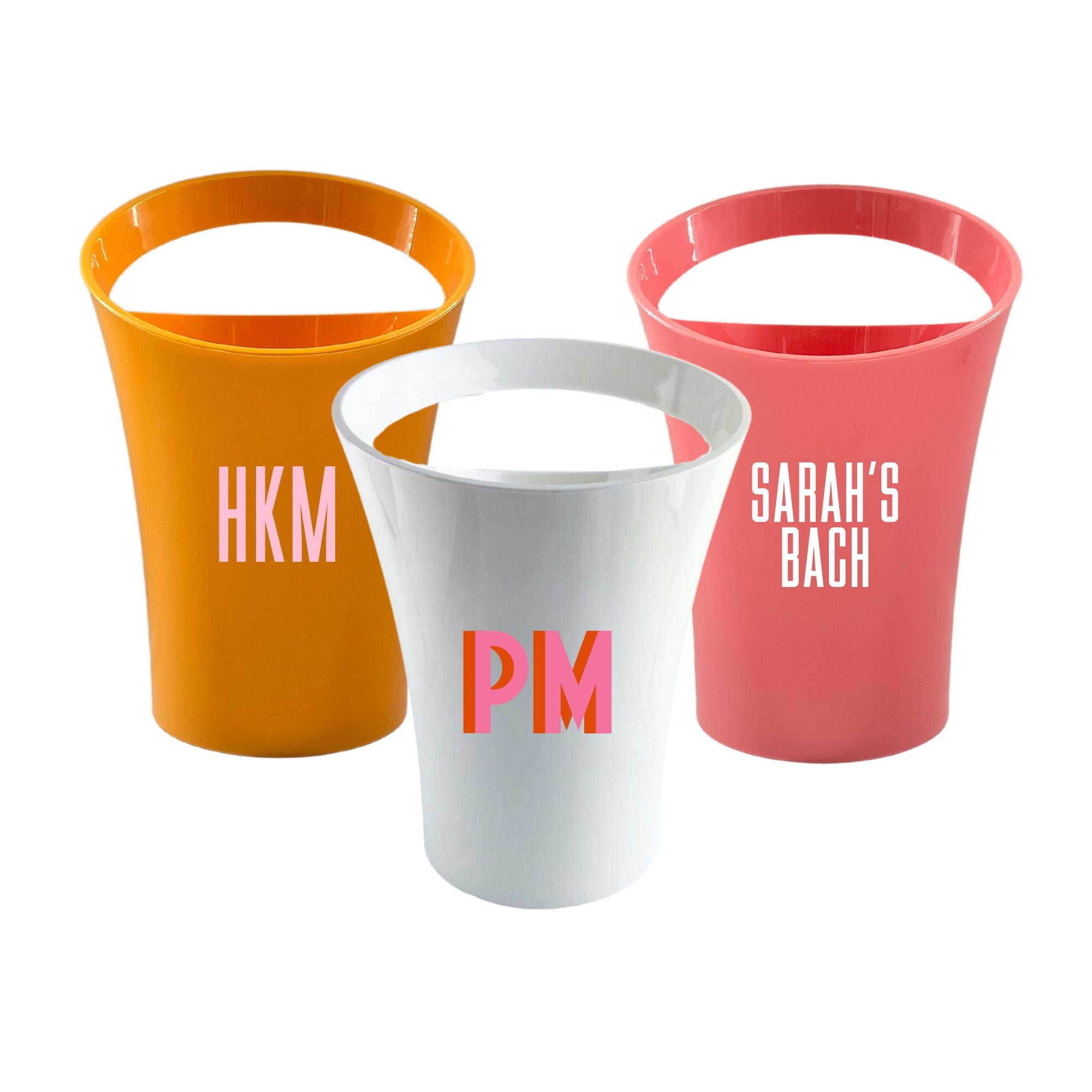 A group of acrylic ice buckets are customized with monograms and custom wording