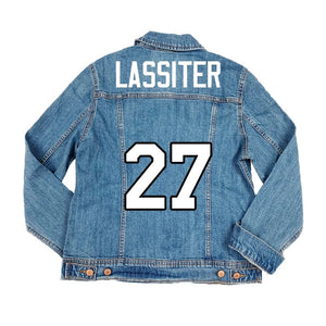 A denim jacket is customized with a red design featuring a custom number and last name.