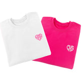 Sweatshirts are laid out to show off their custom heart monogram which is embroidered on the chest.