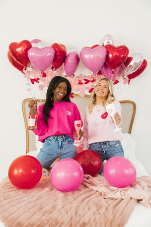 Two girls are seen celebrating Valentine's Day with their custom embroidered sweatshirts.