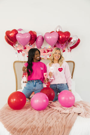 Two girls are seen celebrating Valentine's Day with their custom embroidered sweatshirts.