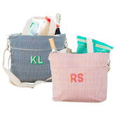 A monogrammed pink and navy stripped cooler tote are filled with snacks and drinks.