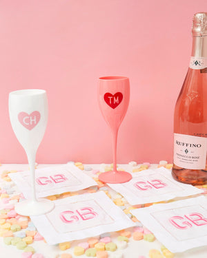 Champagne flutes and cocktail napkins are laid out to show their customization