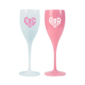 Pink and white champagne flutes are decorated with monogrammed heart designs.