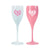 Pink and white champagne flutes are decorated with monogrammed heart designs.