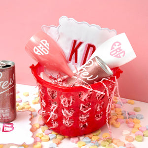 A gift basket with champagne flutes and cocktail napkins is put together for Valentines Day.