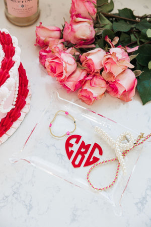 A personalized acrylic tray with a heart holds jewelry