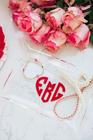 A personalized acrylic tray with a heart holds jewelry