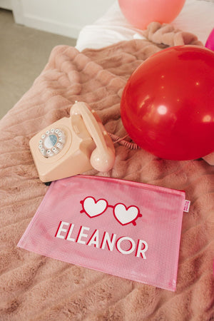 A pink pouch is laid out to show off it's customized design