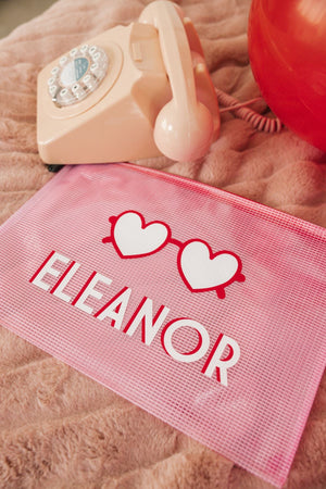 A pink pouch is laid out to show off it's customized design